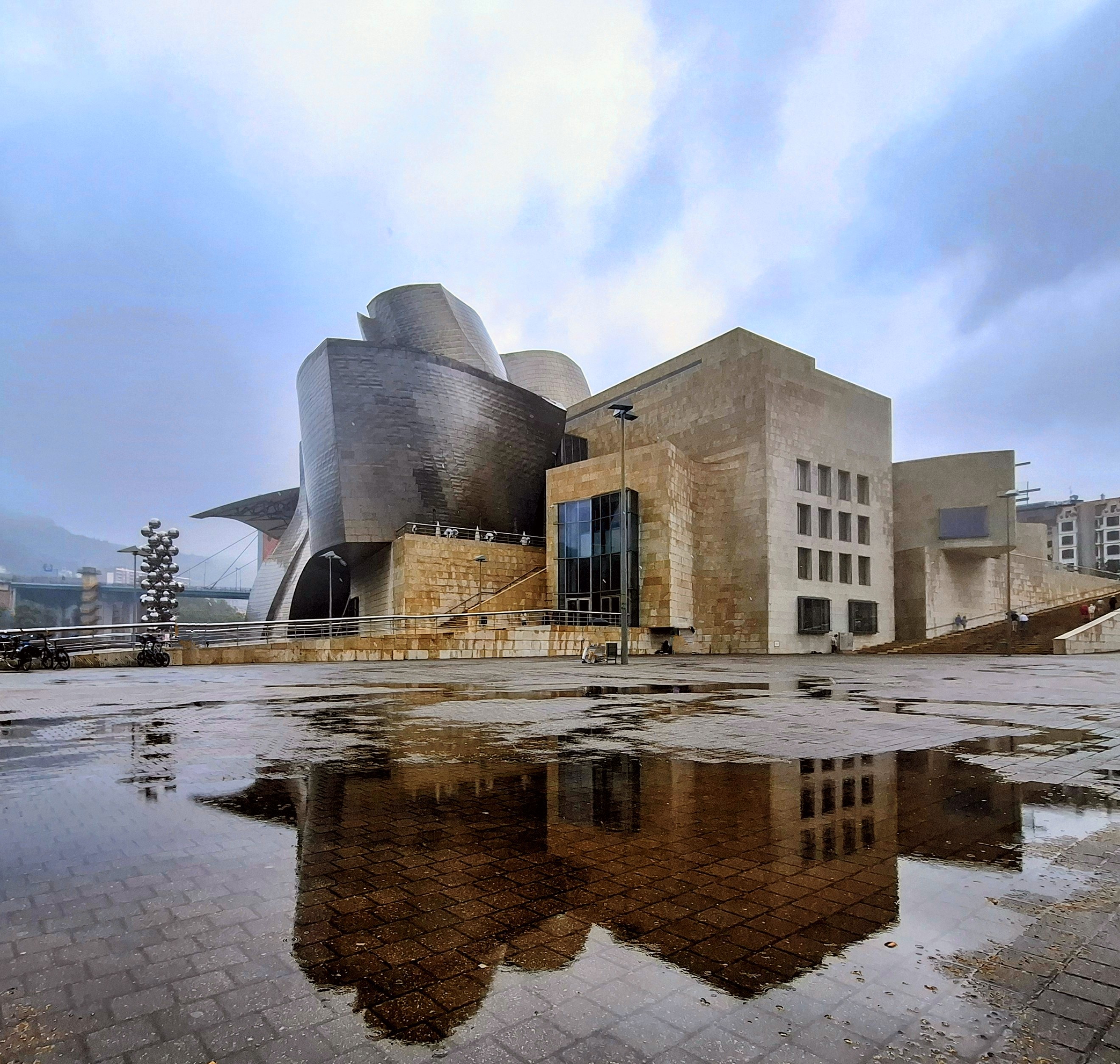 Guggenheim Museum Bilbao reflected in rain puddles